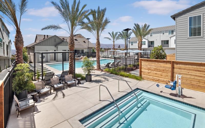 two swimming pools with chairs and palm trees