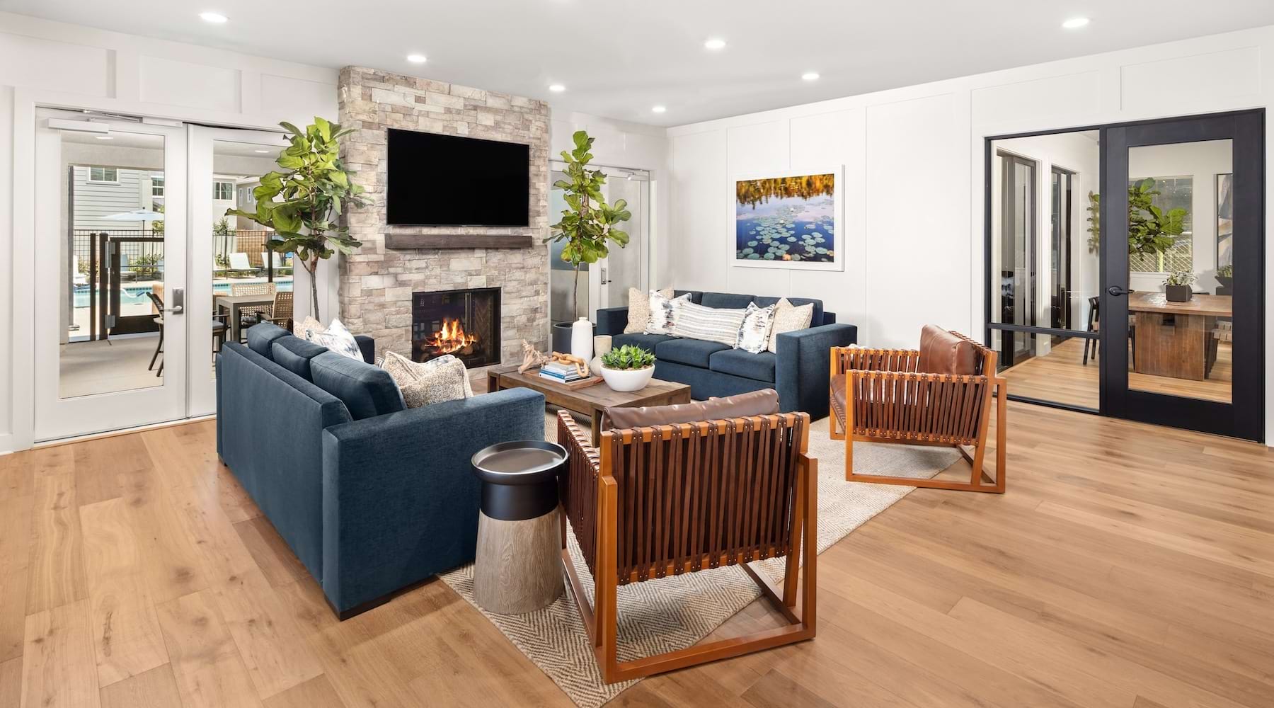 a lounge with a tv, fireplace, couches and chairs